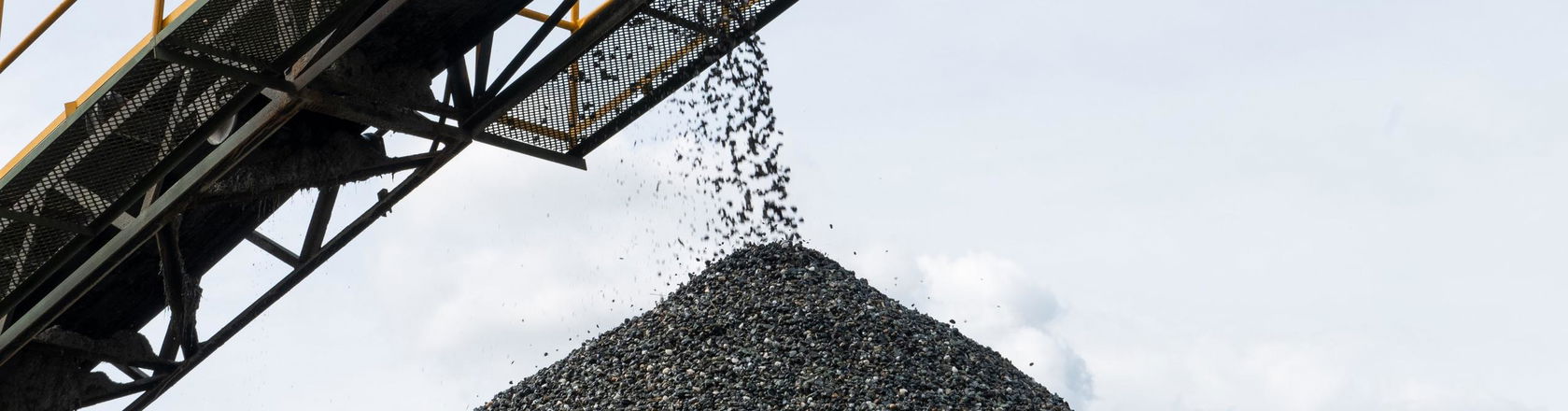 a conveyor belt carrying coking coal and emptying onto a huge pile