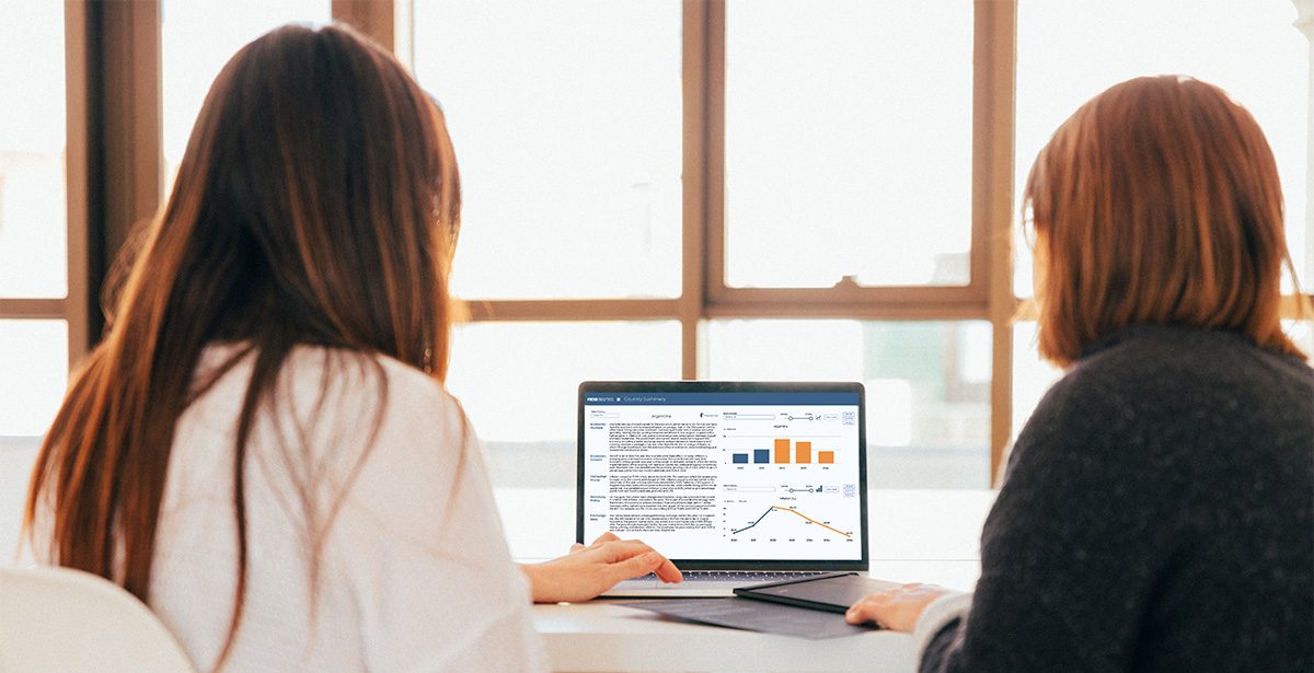 two women working together on a laptop