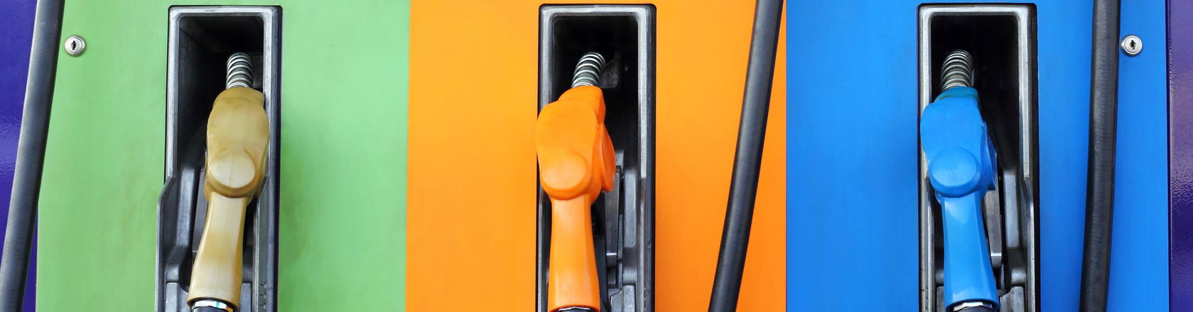 Fuel dispenser machines with green, orange and blue colors. Gasoline pump filling fuel nozzle