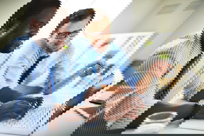 Two business-people using a laptop in an office