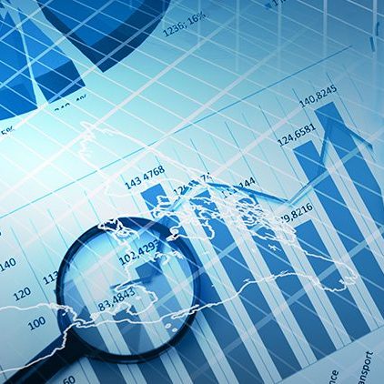 Shot of business documentation illustrating economics graphs under a magnifying lens