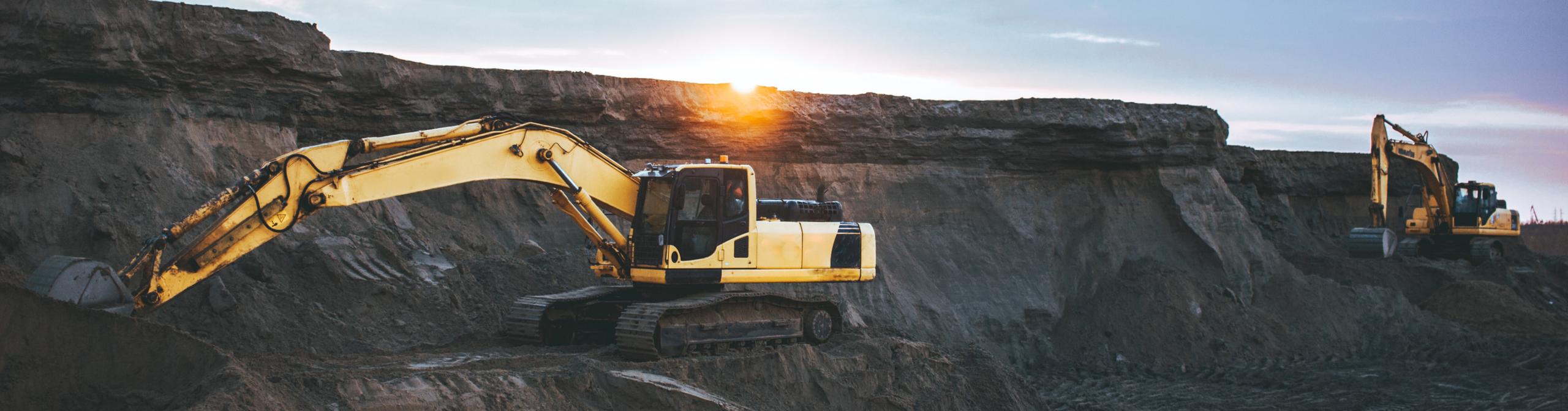a yellow bulldozer is pushing hard coal in a large coal heap